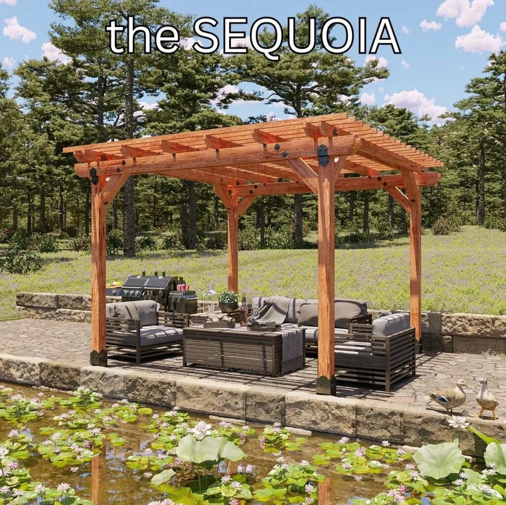 A four-post cedar pergola with a slatted flat canopy over a stone patio of outdoor sofas and a grill, beside a lily pond with pines behind.