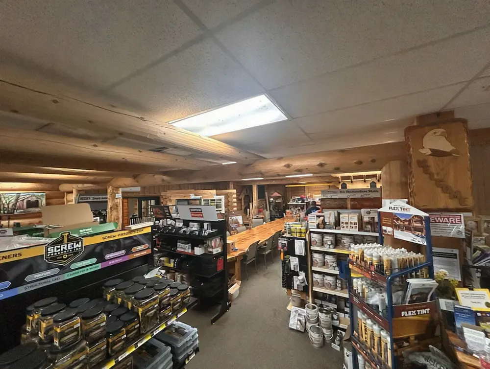 A five second video walking into the Chico showroom, past fastener and caulk displays towards the long live-edge table, under the log beams of the ceiling.