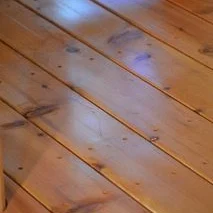 2×6 cedar decking laid on the diagonal, each board's edges eased to a light radius, knots and grain showing across the boards.