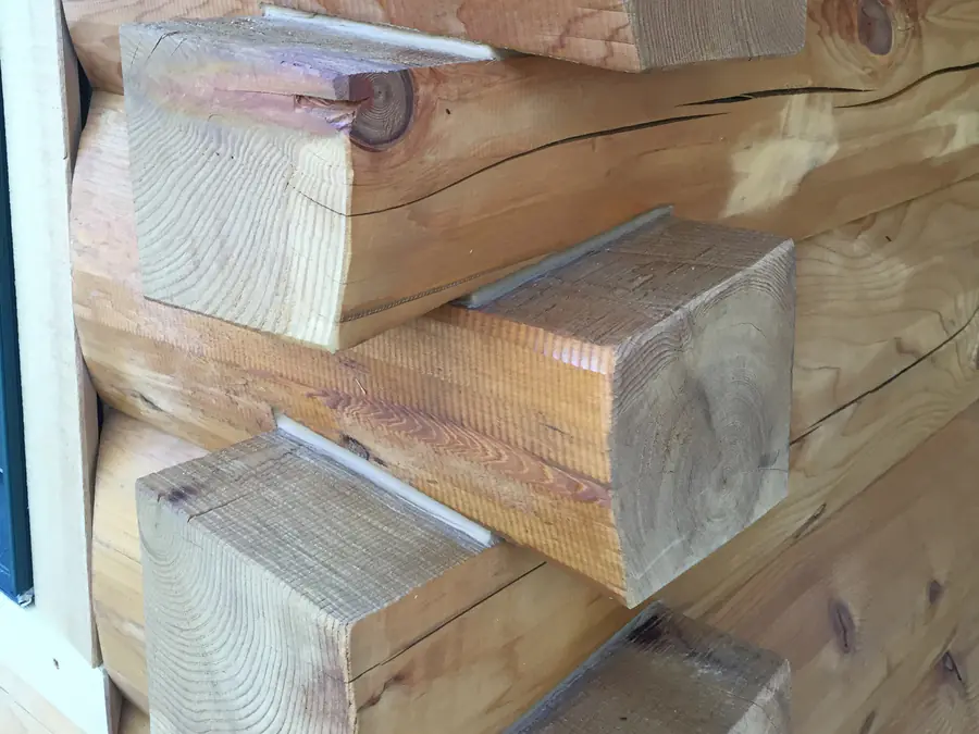 D-log ends up close at a corner, each log rounded on its face and flat on top, stacked and interlocking.