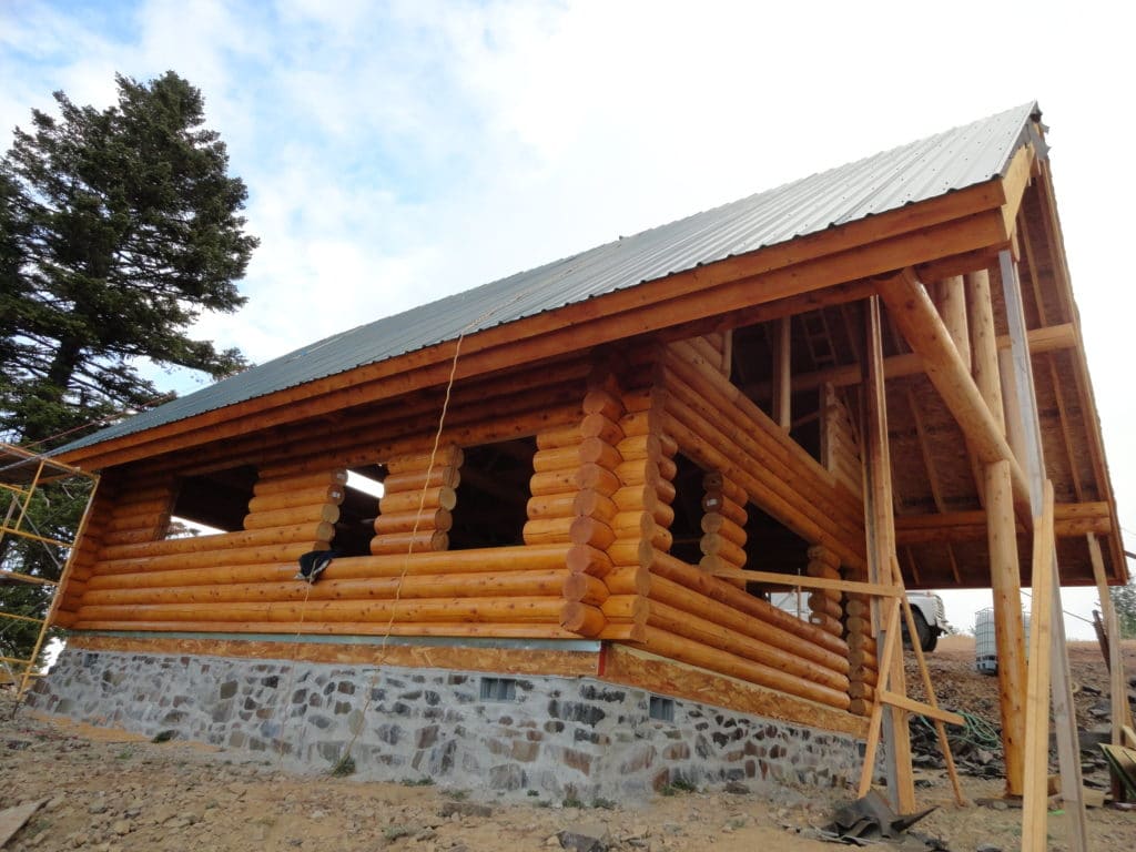 Lakeview home construction, side view of wood sides and stone bottom