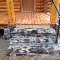 Lakeview wooden front porch with stone stairs