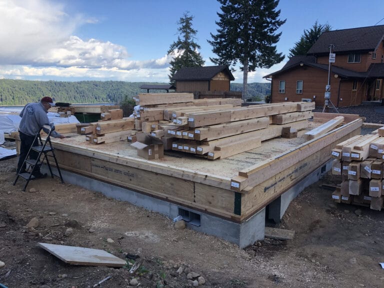 Hood Canal WA cozy log cabin home construction with scenic tree line and water
