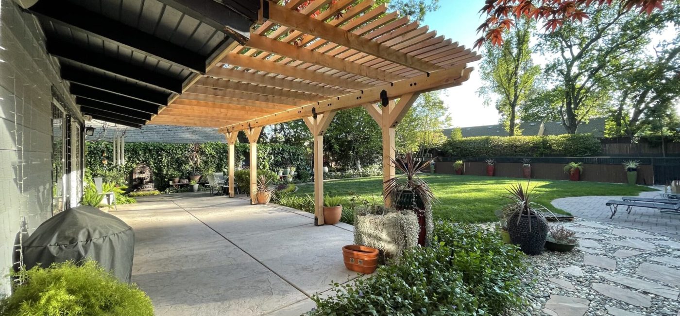 A custom shade structure outdoors over a patio designed by Sierra Log & Timber